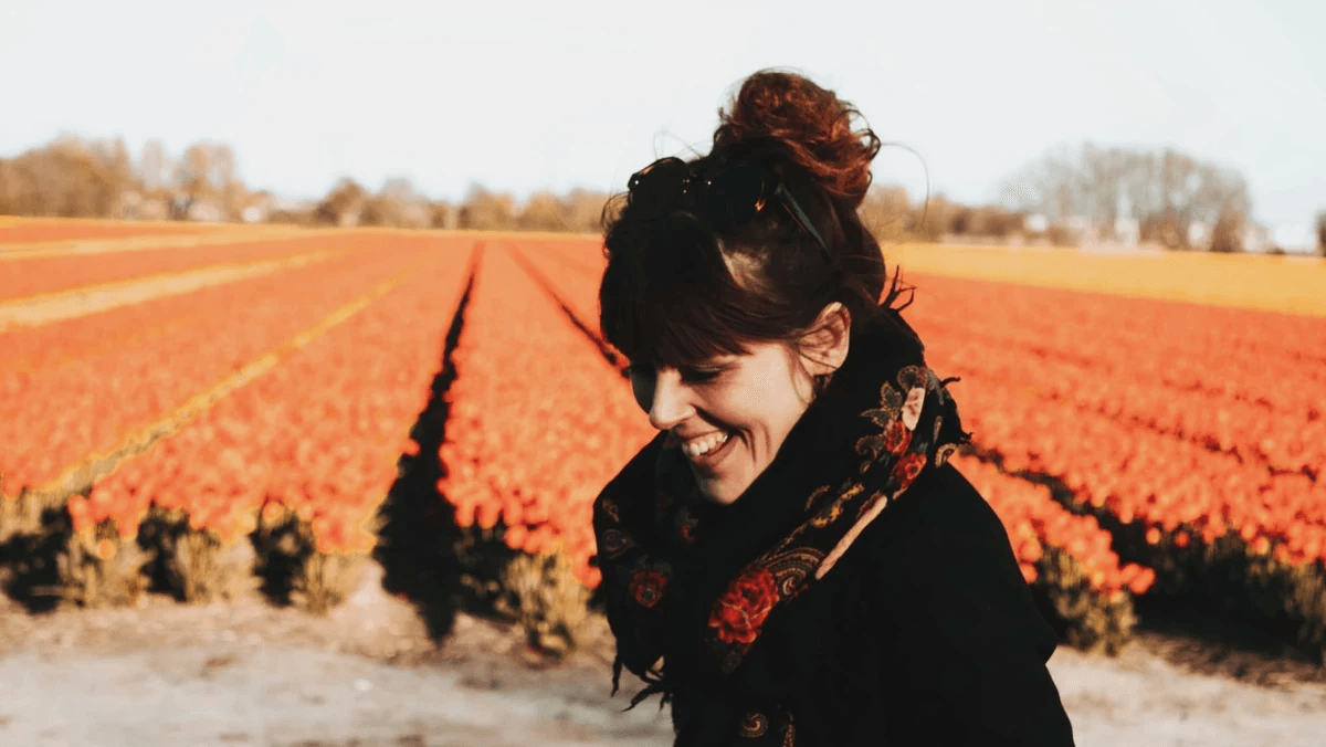 Louise Coffyn souriante devant un champ de tulipes